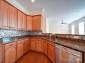 A stylish kitchen featuring stainless steel appliances, granite countertops, and beautiful tile backsplash at 7524 Common Oak Dr, Stanley, NC 28164