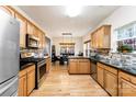 Well-lit kitchen featuring stainless steel appliances, granite countertops, and hardwood floors at 8619 Delamere Ln, Charlotte, NC 28269