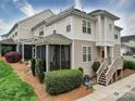 Exterior side view of townhome featuring a private screened porch and well-manicured landscaping at 920 Ashworth Dr, Gastonia, NC 28054