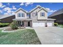 Charming home features a brick and siding facade, a covered front porch, and a spacious three-car garage at 128 Front Porch Dr, Rock Hill, SC 29732