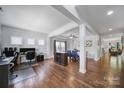 Bright, open-concept living space with hardwood floors features a workstation and a dining area with blue chairs at 128 Front Porch Dr, Rock Hill, SC 29732