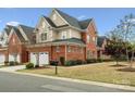 Beautiful brick home with manicured lawn, complemented by mature trees and attractive landscaping at 130 Villa Lake Dr, Fort Mill, SC 29708