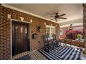 Charming brick porch with rocking chairs, a ceiling fan, and a view of the manicured front yard at 139 S Laurel Ave, Charlotte, NC 28207