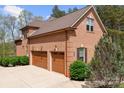 Brick exterior with a three car garage, and a paved driveway at 164 Crooked Branch Way, Troutman, NC 28166