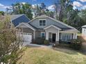 Charming two-story home with stone accents, a two-car garage, and a well-maintained front yard at 1718 Still River Way, Fort Mill, SC 29708