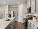 Modern kitchen with stainless steel appliances, gray cabinets, and a spacious sink at 1726 Braemar Village Dr, Monroe, NC 28110