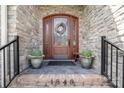 Elegant front entrance features a beautiful wood door with glass detailing, enhanced by decorative plants at 1849 Oakmont Dr, Denver, NC 28037