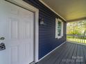 Close-up of the front door and cozy porch with a white railing at 1903 Marshall Ave, Gastonia, NC 28052