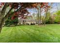 Expansive front lawn with mature trees leading to a beautifully maintained traditional-style home at 19040 Mary Ardrey Cir, Cornelius, NC 28031