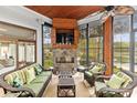 Cozy sunroom with stone fireplace, wood ceiling, and panoramic lake views at 19040 Mary Ardrey Cir, Cornelius, NC 28031
