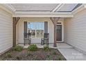Cozy front porch with rocking chairs, decorative columns, and a view of the well-manicured landscaping at 2017 Autumn Dr, Monroe, NC 28110