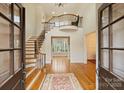 A grand foyer with a staircase, hardwood floors, and elegant details that welcomes you into the home at 20635 Queensdale Dr, Cornelius, NC 28031