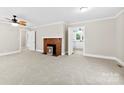 Bright living room featuring neutral walls, a vintage brick fireplace, and an inviting open doorway to the kitchen at 2300 Linwood Rd, Gastonia, NC 28052