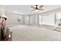 Cozy living room with a brick fireplace, neutral walls, large windows, and carpeted floors, creating a comfortable atmosphere at 2300 Linwood Rd, Gastonia, NC 28052
