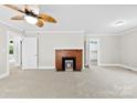 Spacious living room with neutral walls, a brick fireplace, modern ceiling fan, and views into adjoining rooms at 2300 Linwood Rd, Gastonia, NC 28052
