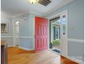 Bright foyer with hardwood floors, light blue walls, and a red front door, creating a warm and inviting entry at 2812 Edgebrook Cir, Matthews, NC 28105