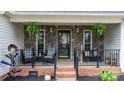 Inviting front porch with stone accent wall, stylish seating, and decorative plants, offering a warm welcome at 2987 Irish St, Newton, NC 28658