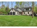 Beautifully landscaped front yard with lush green grass and a charming new two-story home at 3038 Northampton Dr, Charlotte, NC 28210