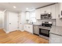 Modern kitchen featuring white cabinets, stainless steel appliances, and granite countertops at 307 S Ransom St, Gastonia, NC 28052