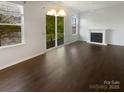 Bright living room featuring hardwood floors, a fireplace, and a door leading to a balcony with outdoor views at 3489 Chagall Ct, Charlotte, NC 28205