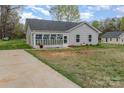 Home with a sunroom, and long driveway, complemented by a well-maintained lawn at 413 E Henderson Es St, East Spencer, NC 28144