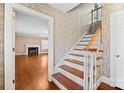Inviting entryway with hardwood stairs and patterned wallpaper, creating a stylish and classic first impression at 431 Sullivan Rd, Statesville, NC 28677