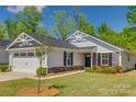 Charming single-story home featuring stone accents, a well-kept lawn, and a two car garage at 4503 Hunton Dale Nw Rd, Concord, NC 28027