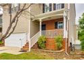 Lovely covered front porch with brick accents, white railing, and lush greenery enhancing curb appeal at 5664 Norwood Ridge Dr, Rock Hill, SC 29732