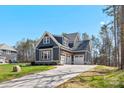 Beautiful home showcasing architectural shingles, a well-maintained lawn, and a three-car garage with a pergola at 605 Arrow Point Ln, Davidson, NC 28036