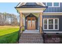 Inviting front entryway with a stylish wooden door, brick steps, and dark metal railings, showcasing great curb appeal at 605 Arrow Point Ln, Davidson, NC 28036