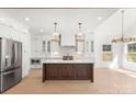Bright, open-concept kitchen with stainless steel appliances, white cabinetry, and a large center island at 605 Arrow Point Ln, Davidson, NC 28036