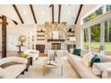 Cozy living room features a stone fireplace, beamed ceiling, and natural light at 6422 Chimney Bluff Rd, Lancaster, SC 29720