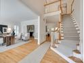 Elegant foyer with hardwood floors, staircase, and views into the living and dining rooms at 6804 Riesman Ln, Charlotte, NC 28210