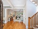 Spacious foyer featuring wood floors, staircase, and an open view into a bright and stylishly furnished living room at 8912 Heydon Hall Cir, Charlotte, NC 28210