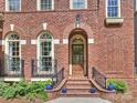 An arched brick entrance with steps, black railings, and landscaping leads to a wood front door with glass panes at 8912 Heydon Hall Cir, Charlotte, NC 28210