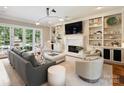 A comfortable living room with a fireplace, built-in bookcases, French doors, and a neutral color palette at 8912 Heydon Hall Cir, Charlotte, NC 28210