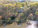 Stunning aerial view of a lakeside home nestled among mature trees, offering privacy and natural beauty at 925 Lanier Ln, Monroe, NC 28110