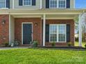 Cozy front porch with brick columns, lovely landscaping and a freshly-mowed lawn at 10107 Atkins Ridge Dr, Charlotte, NC 28213