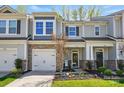 Charming townhome featuring stone accents, a one-car garage, and a beautifully landscaped front yard at 1066 Chicory Trce, Lake Wylie, SC 29710
