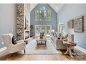Elegant living room boasts a vaulted ceiling, a stone fireplace, and French doors leading to the backyard at 119 Taylor Ct, Mooresville, NC 28117