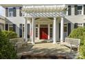 Inviting front entrance with a red door framed by white columns and twin benches at 1212 Queens Rd, Charlotte, NC 28207
