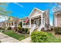 Attractive two-story home featuring a welcoming front porch, beautiful landscaping, and the American flag at 12424 Bradford Park Dr, Davidson, NC 28036