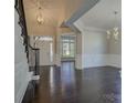 Elegant foyer featuring dark hardwood floors, a grand staircase, and a decorative chandelier at 14916 Creeks Edge Dr, Charlotte, NC 28278