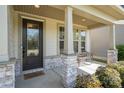 Inviting front porch with stone accents and charming bench at 15212 Keyes Meadow Way, Huntersville, NC 28078