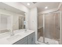 Modern bathroom with double vanity, large mirror, and glass-enclosed shower with tiled walls at 1721 Braemar Village Dr, Monroe, NC 28110
