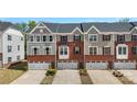 Attractive brick and gray sided townhomes with one-car garages and well-maintained landscaping at 2619 Grantham Place Dr, Fort Mill, SC 29715