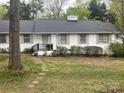 White brick home with a black roof, welcoming front porch, and verdant lawn at 2701 Rea Rd, Charlotte, NC 28226