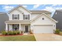 Charming two-story home with gray shutters, a covered porch, an attached garage and well-kept lawn at 2893 Yeager Nw Dr, Concord, NC 28027