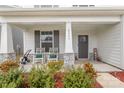 Inviting front porch with rocking chairs, decorative plants, and stacked stone pillar accents at 2893 Yeager Nw Dr, Concord, NC 28027