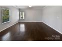 Spacious, bright room with gleaming hardwood floors and a large window, perfect for customization at 3026 S Devon St, Charlotte, NC 28213